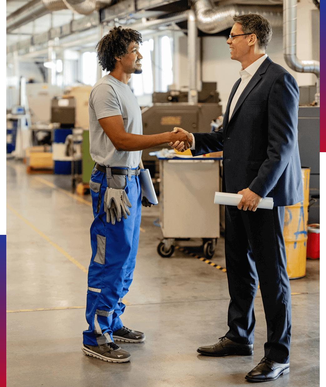 Two men shaking hands in a factory.